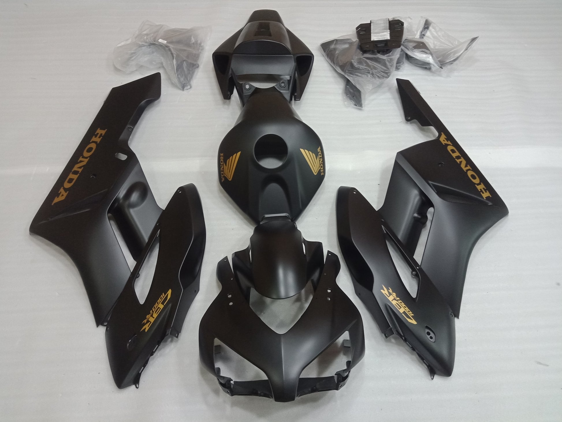 Set of black motorcycle fairings including panels, bolts, windscreen, and heat shield, laid out on a white background.
