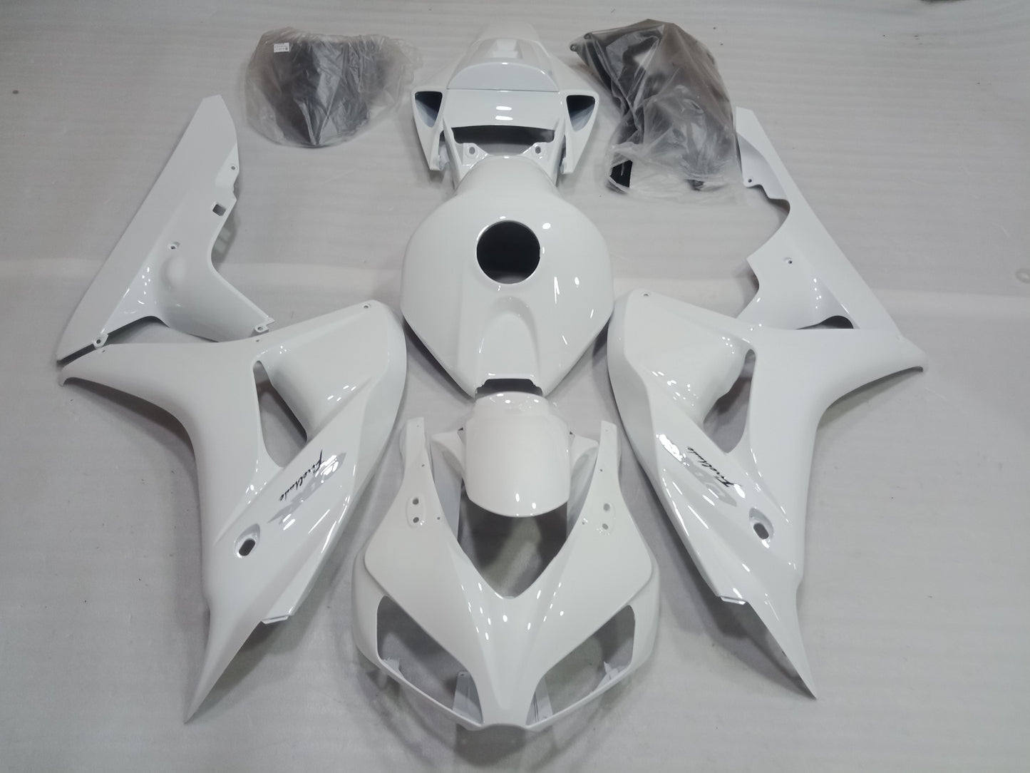 White fairing kit for Honda CBR1000RR motorcycle, displayed without being installed, including various panels and fairing parts.