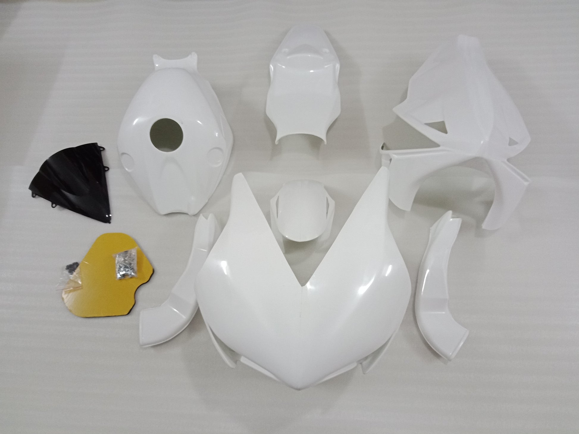Unpainted fiberglass fairing kit for HONDA CBR1000RR motorcycle laid out on a white surface.