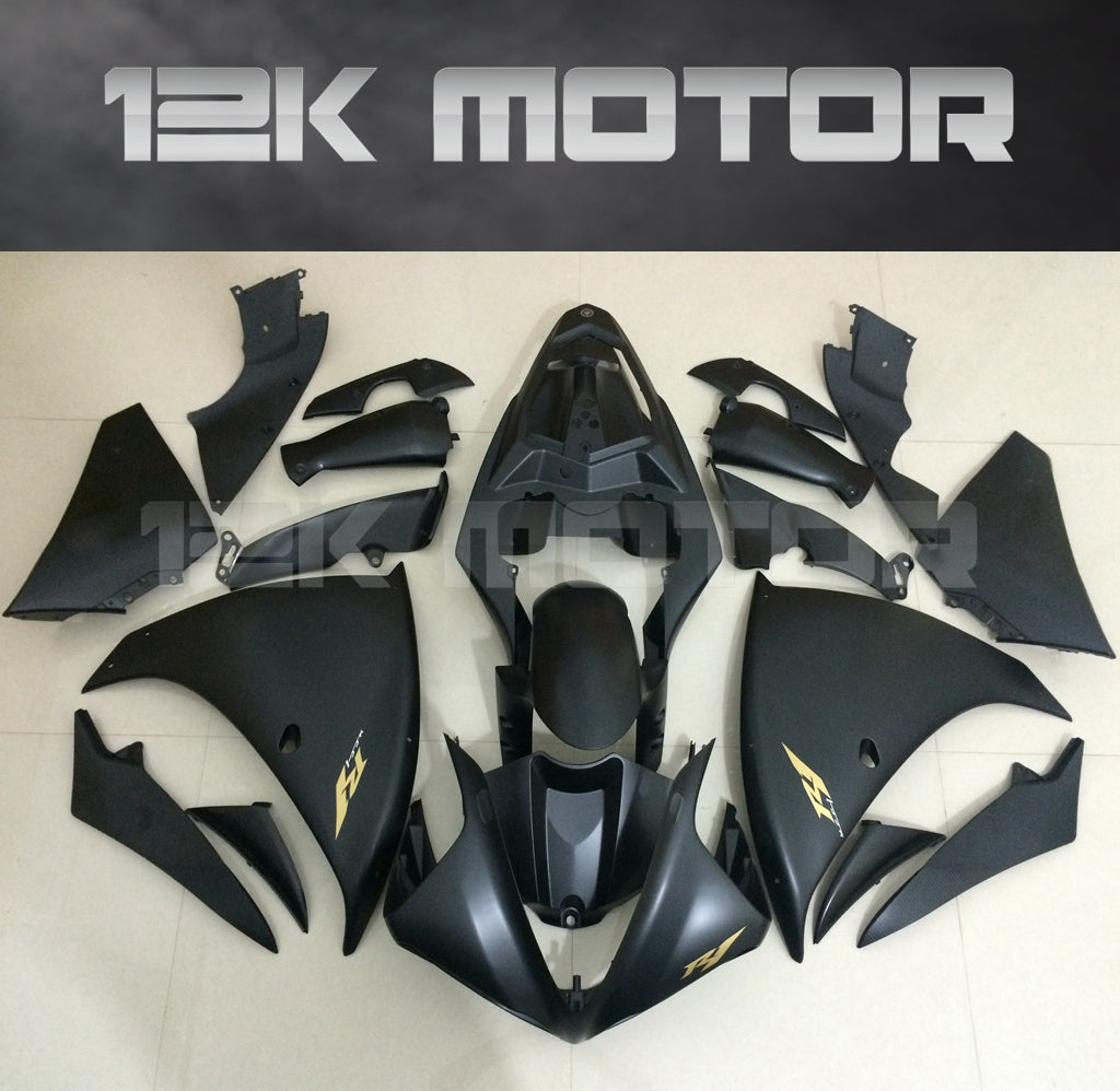 Set of matte black motorcycle fairings with gold stickers laid out on a flat surface, including panels for a Yamaha YZF R1 model from 2009-2012.