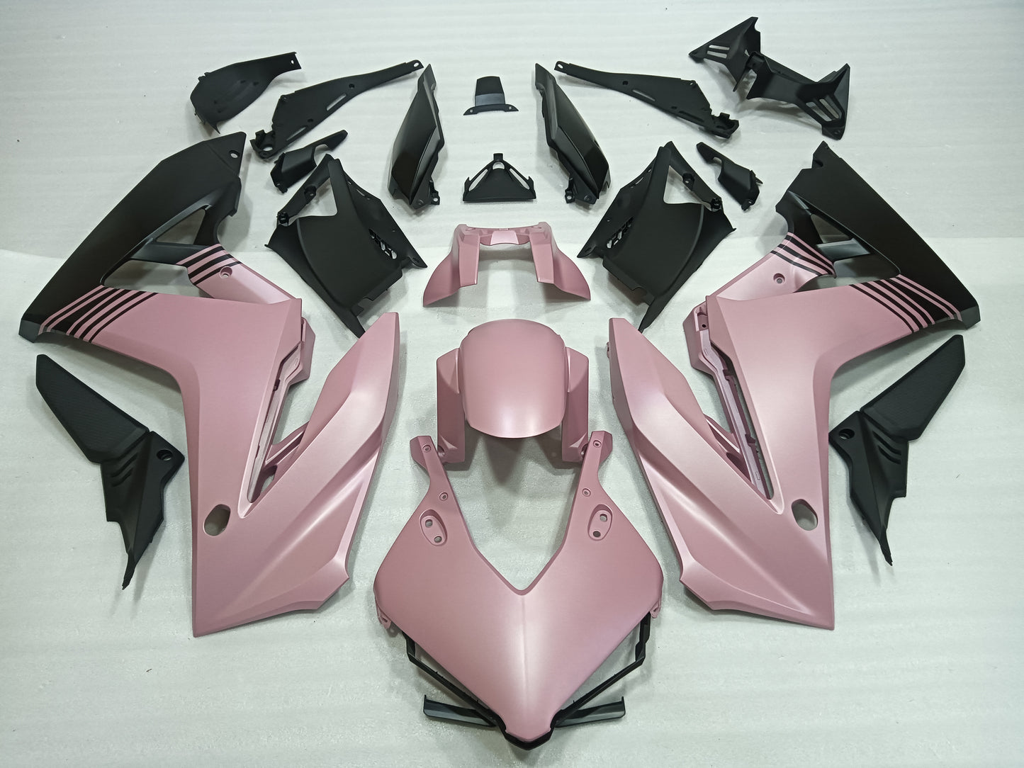 Pink and black motorcycle body parts on a white background