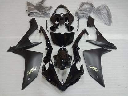 A set of black motorcycle fairings laid out on a white surface, including various panels and a windscreen.