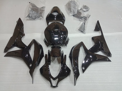 A set of gloss black motorcycle fairings laid out on a white surface, including various panels and bolts, for a Honda CBR600RR.