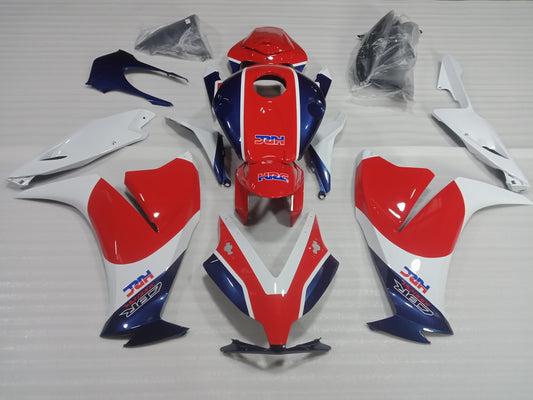 A set of motorcycle fairings for a Honda CBR1000RR in red, white, and blue color scheme, displayed on a table.