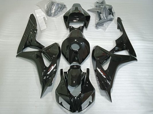 Set of black motorcycle fairings including panels, bolts, windscreen, and heat shield laid out on a white background.
