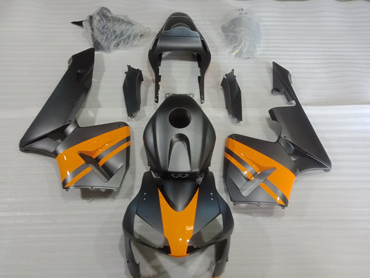 Set of motorcycle fairings in matte black with yellow accents, including various panels and accessories, displayed on a white background.