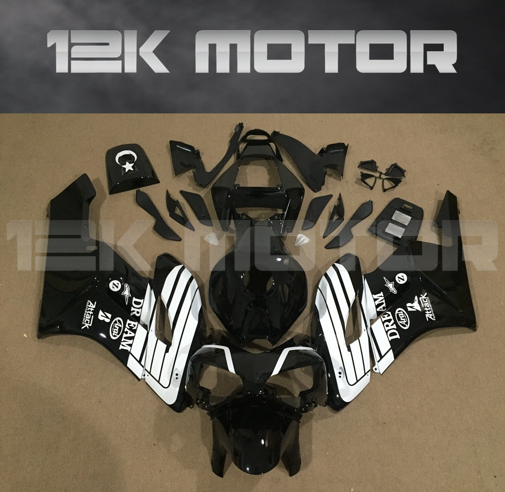 Aftermarket black fairing kit for HONDA CBR1000RR motorcycle, displayed on a table with various pieces and parts including fairing panels, bolts, windscreen, and heat shield.