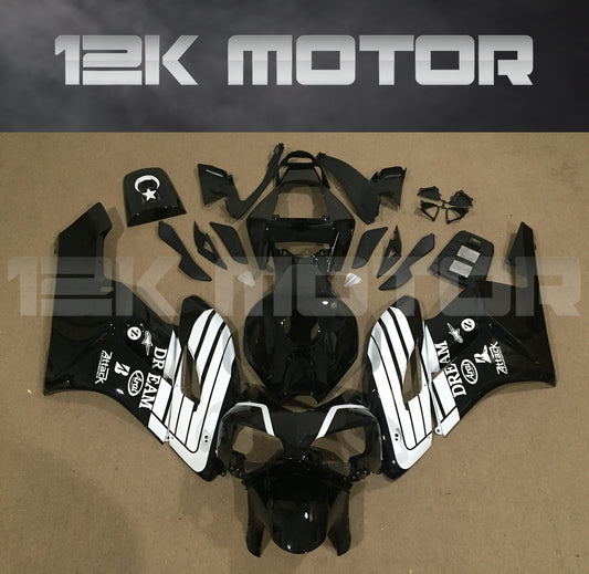 Aftermarket black fairing kit for HONDA CBR1000RR motorcycle, displayed on a table with various pieces and parts including fairing panels, bolts, windscreen, and heat shield.