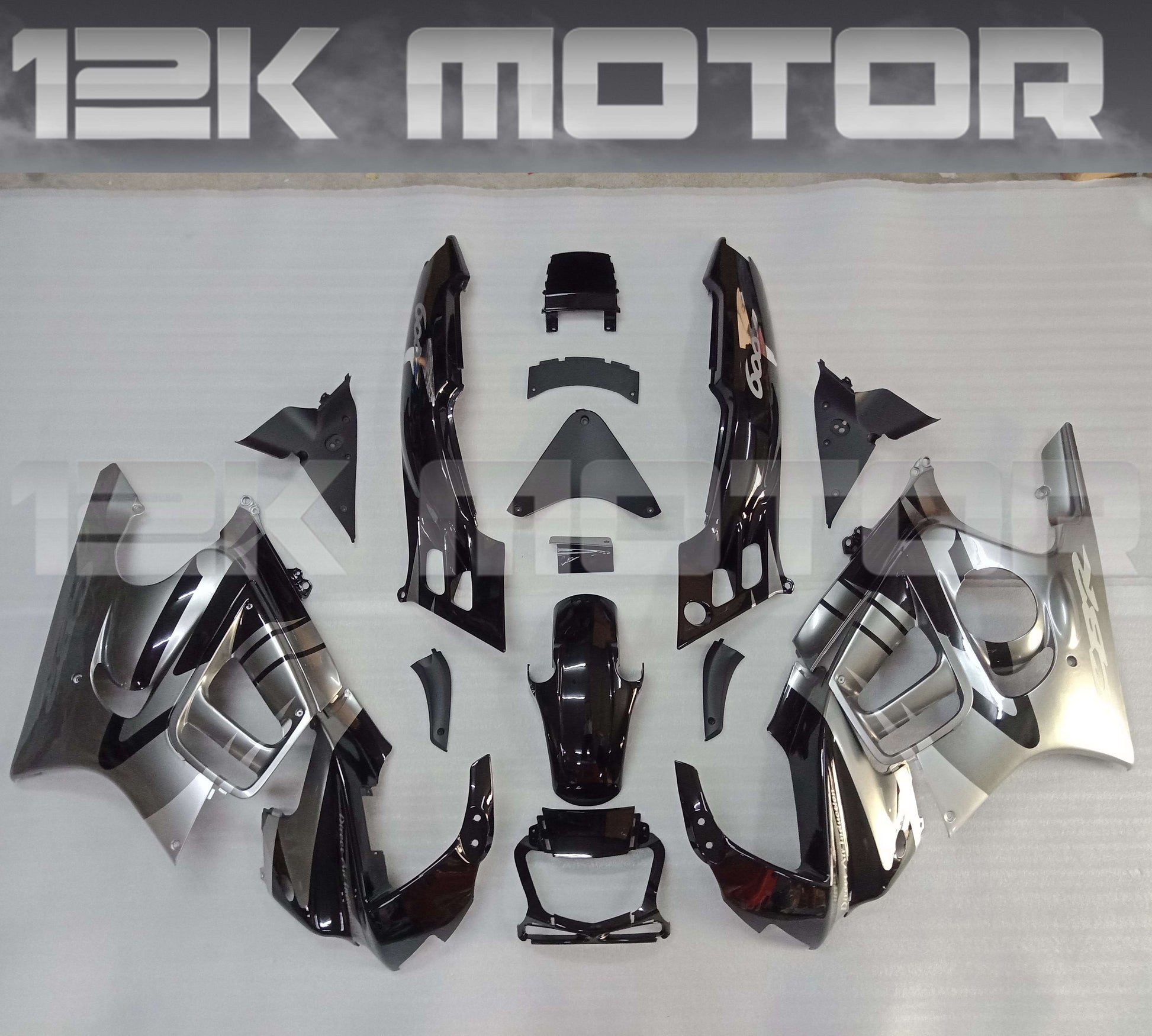 Aftermarket fairing kits for HONDA CBR600F laid out on a table, featuring various panels in black and silver color scheme.