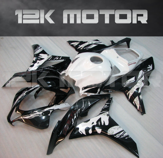 Set of black and white motorcycle fairings for Honda CBR600RR, including various panels and parts, displayed on a table.