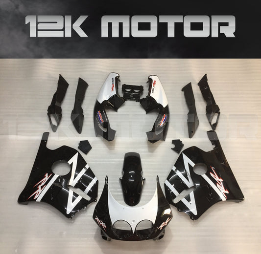 Aftermarket fairing kit for HONDA CBR250RR MC22, displayed on a table, featuring a black and white design with red accents.