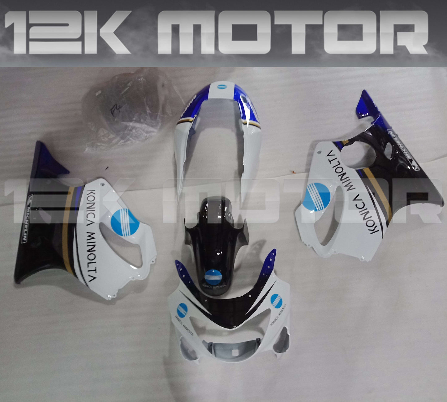Aftermarket fairing kit for HONDA CBR600RR F4 1999 2000 displayed on a table, consisting of various motorcycle fairing pieces in black, white, and blue colors.