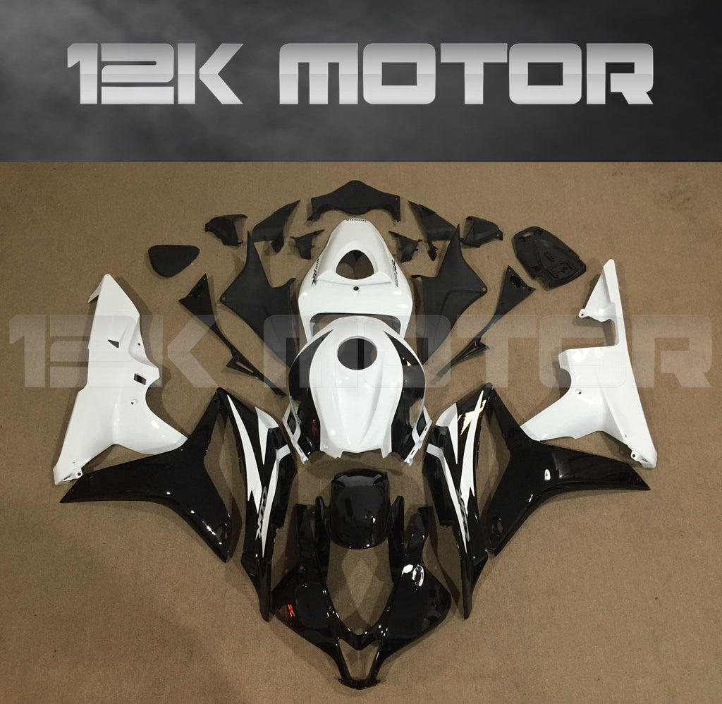 Set of black and white Honda CBR600RR motorcycle fairings displayed on a table, including various panels and fairing bolts.
