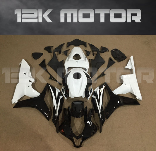 Set of black and white Honda CBR600RR motorcycle fairings displayed on a table, including various panels and fairing bolts.