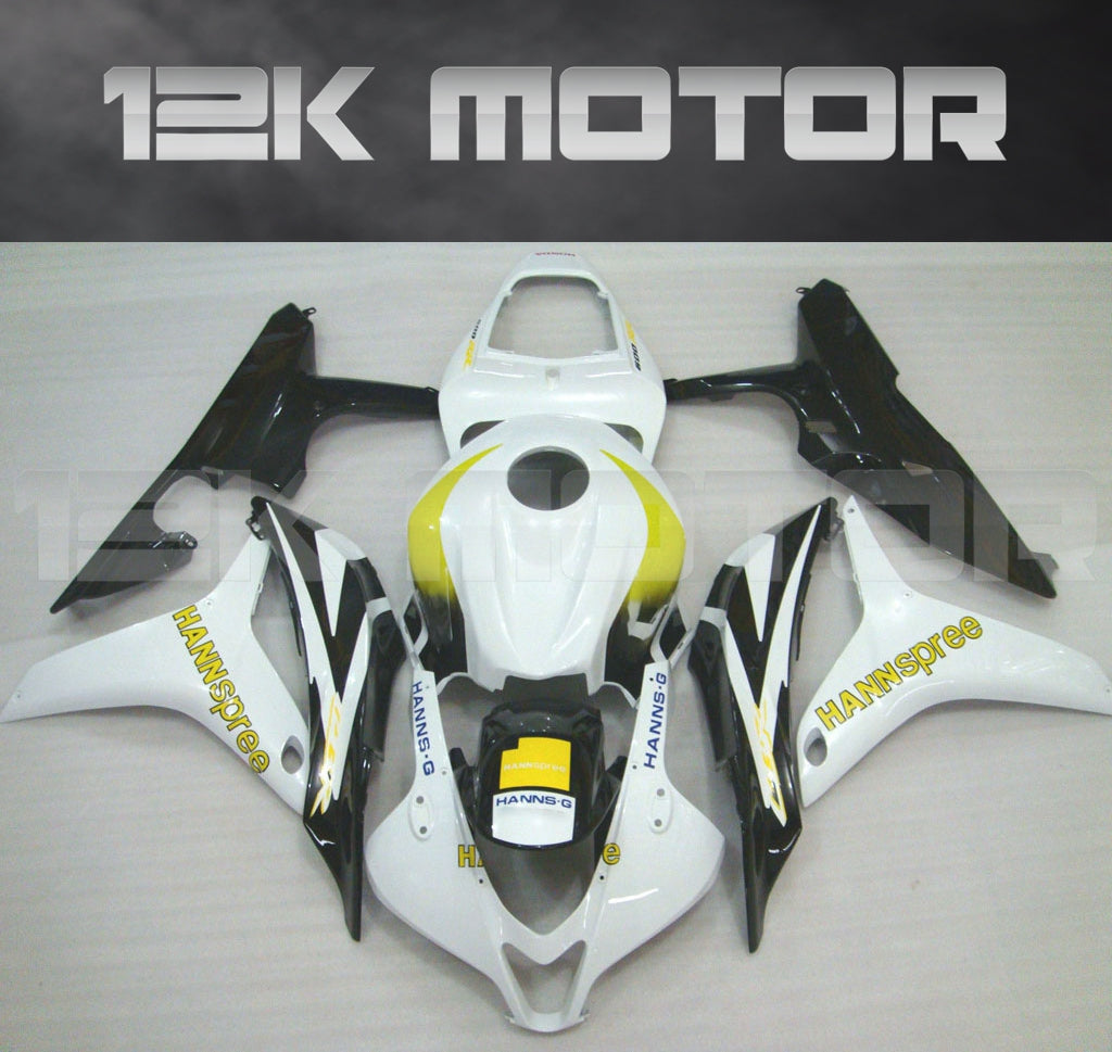 Aftermarket black, white, and yellow Honda CBR600RR motorcycle fairing set displayed on a table.