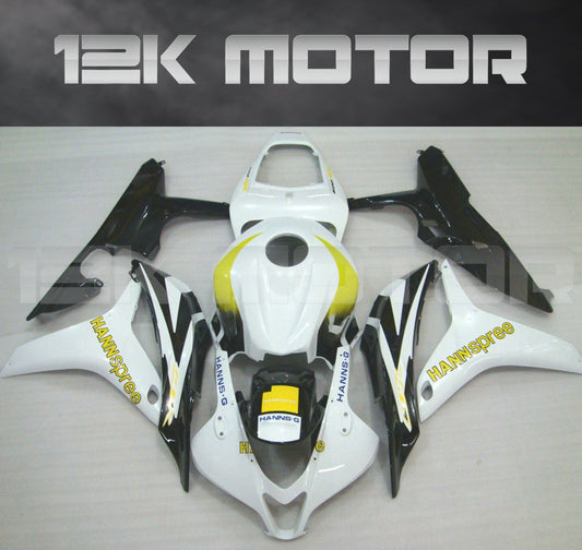 Aftermarket black, white, and yellow Honda CBR600RR motorcycle fairing set displayed on a table.