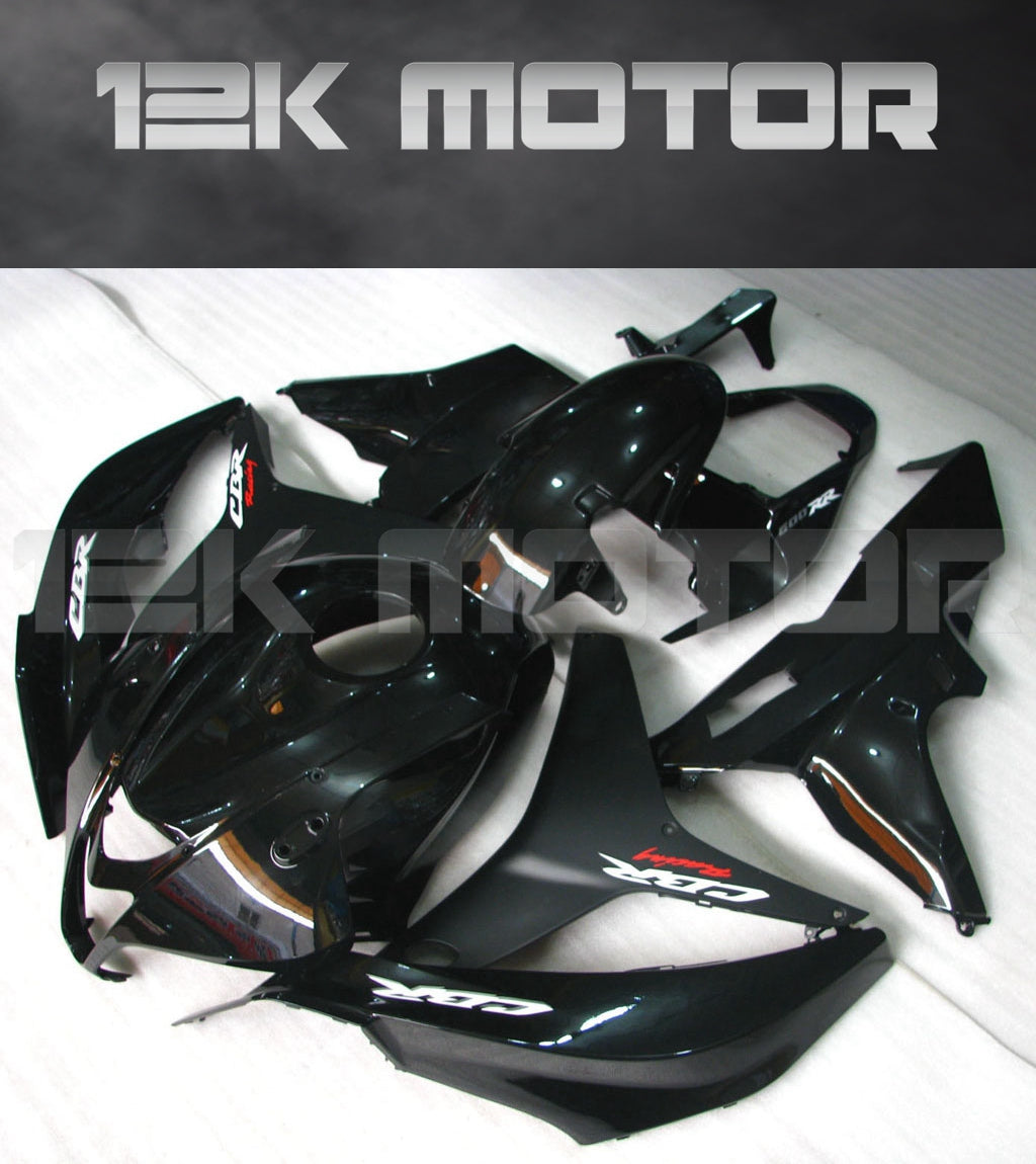 A set of gloss black motorcycle fairings for a HONDA CBR600RR, displayed on a table.