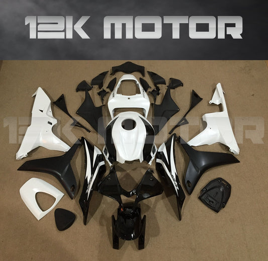 Aftermarket black and white fairing kit for Honda CBR600RR motorcycle, laid out on a table.