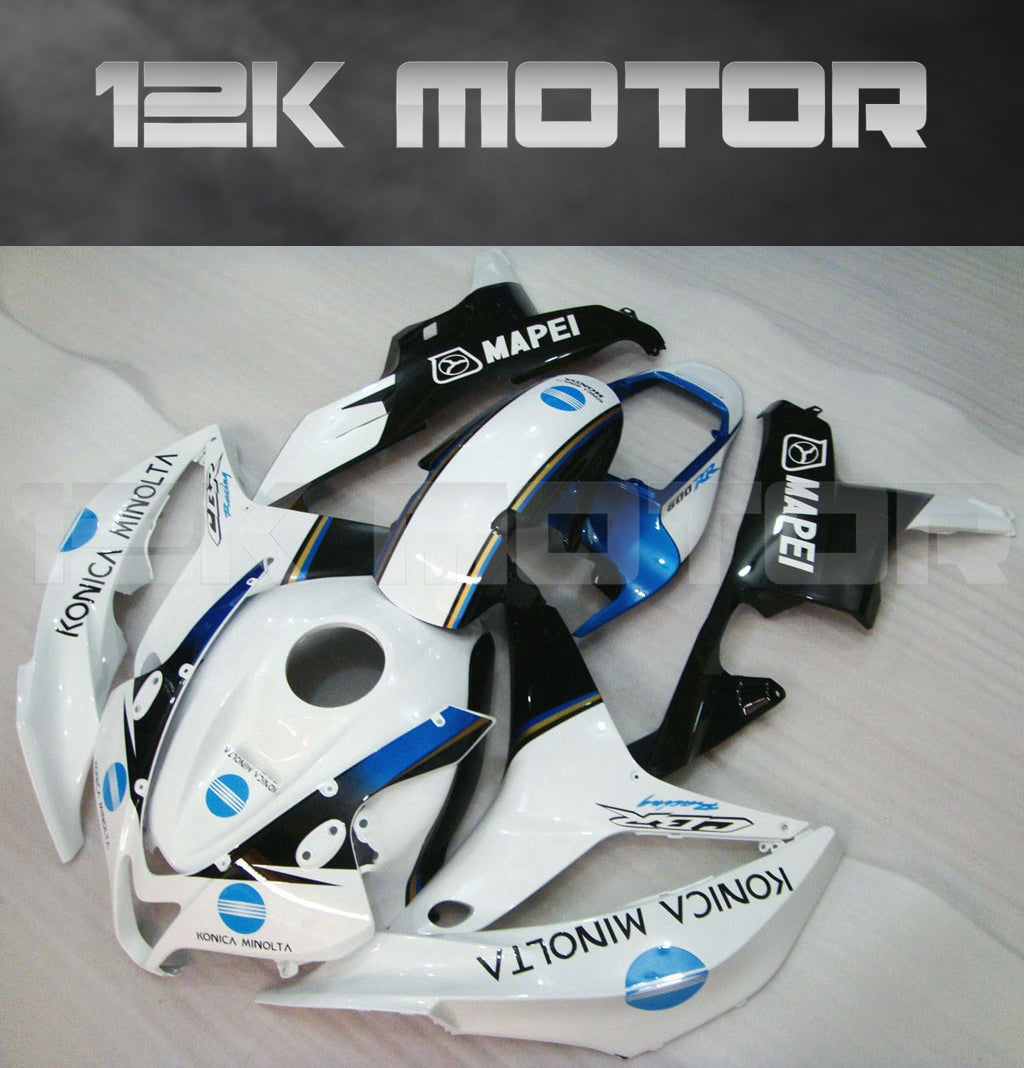 Aftermarket Honda CBR600RR motorcycle fairing kit in black, white, and blue color scheme, displayed on a table.