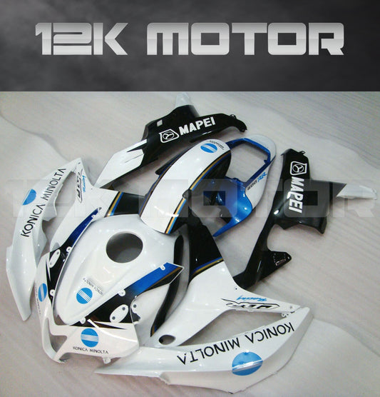 Aftermarket Honda CBR600RR motorcycle fairing kit in black, white, and blue color scheme, displayed on a table.