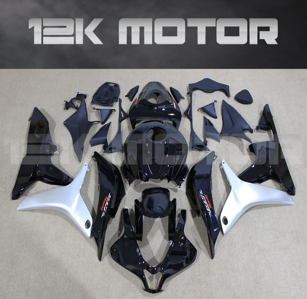 Aftermarket gloss black Honda CBR600RR fairing kit set displayed on a table, including various fairing panels and bolts.