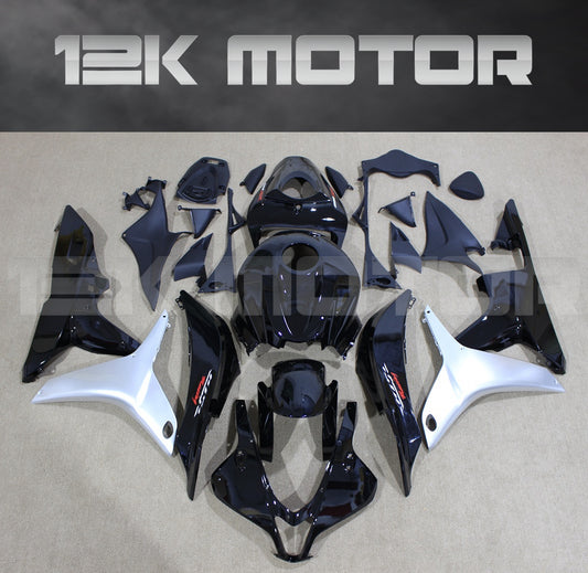 Aftermarket gloss black Honda CBR600RR fairing kit set displayed on a table, including various fairing panels and bolts.