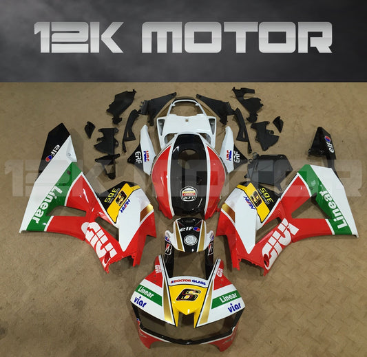 Aftermarket fairing kit for Honda CBR600RR motorcycle displayed on a table, featuring a multicolor design with sponsor logos.