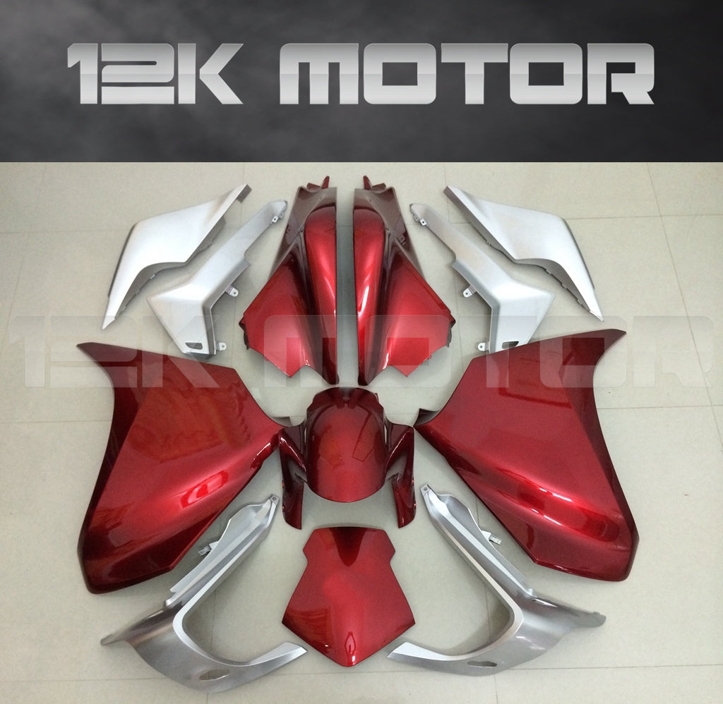 A set of dark red motorcycle fairings laid out on a floor, including various panels and parts typically used for the exterior body of a HONDA VFR1200.