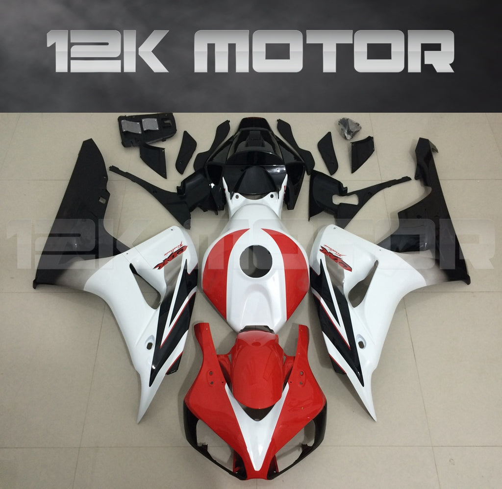 Aftermarket red, white, and black fairing kit for Honda CBR1000RR motorcycle, displayed on a table.