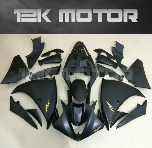 Set of matte black motorcycle fairings with gold stickers laid out on a flat surface, including panels for a Yamaha YZF R1 model from 2009-2012.