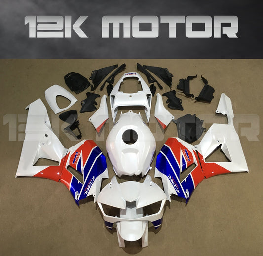 Aftermarket fairing kit for HONDA CBR600RR motorcycle, featuring a white, orange, and blue color scheme laid out on a table.