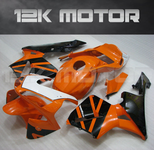 An orange and black motorcycle fairing kit laid out on a surface, including various panels and a windscreen.