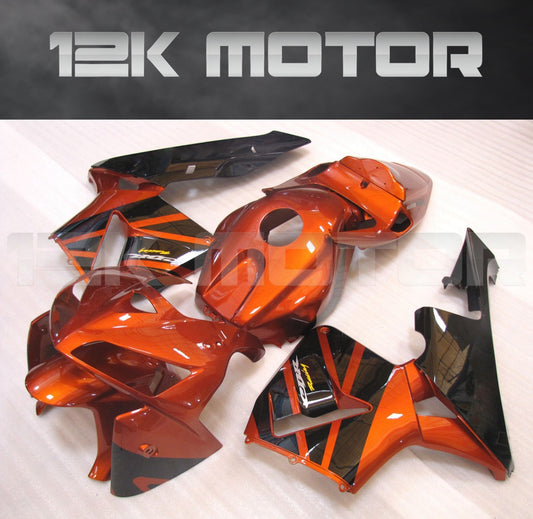 An orange and black aftermarket fairing kit for HONDA CBR600RR motorcycle, laid out on a wooden surface.