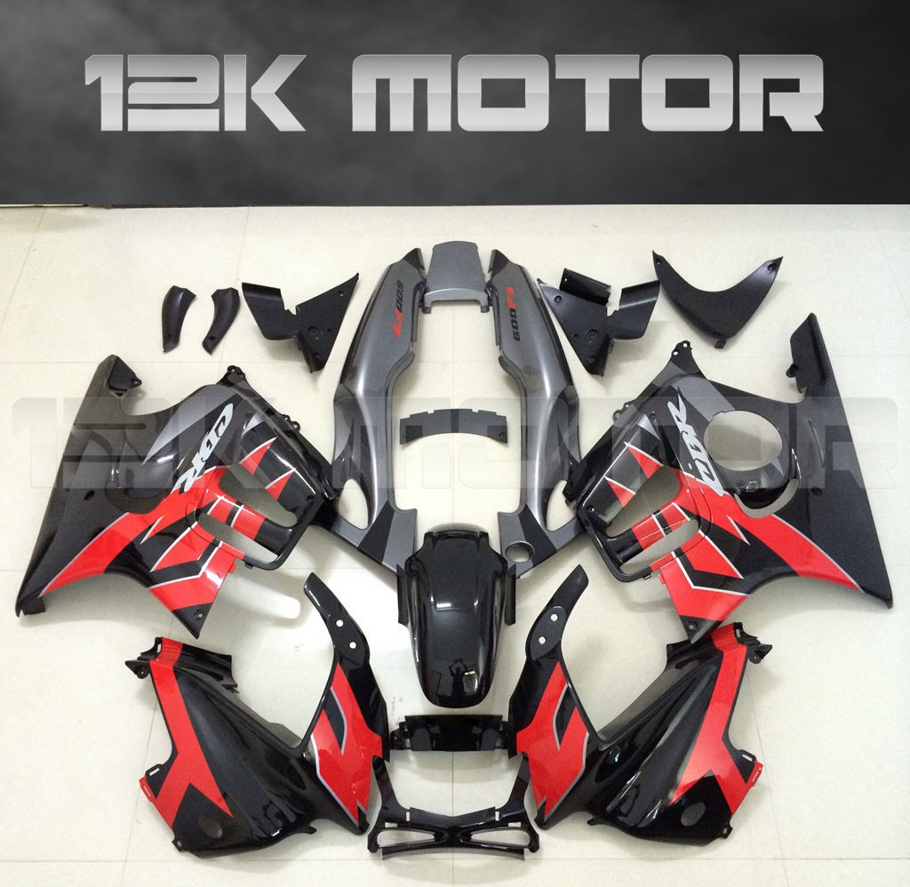 A set of aftermarket motorcycle fairings in red and black, designed for HONDA CBR600F models, laid out on a surface.