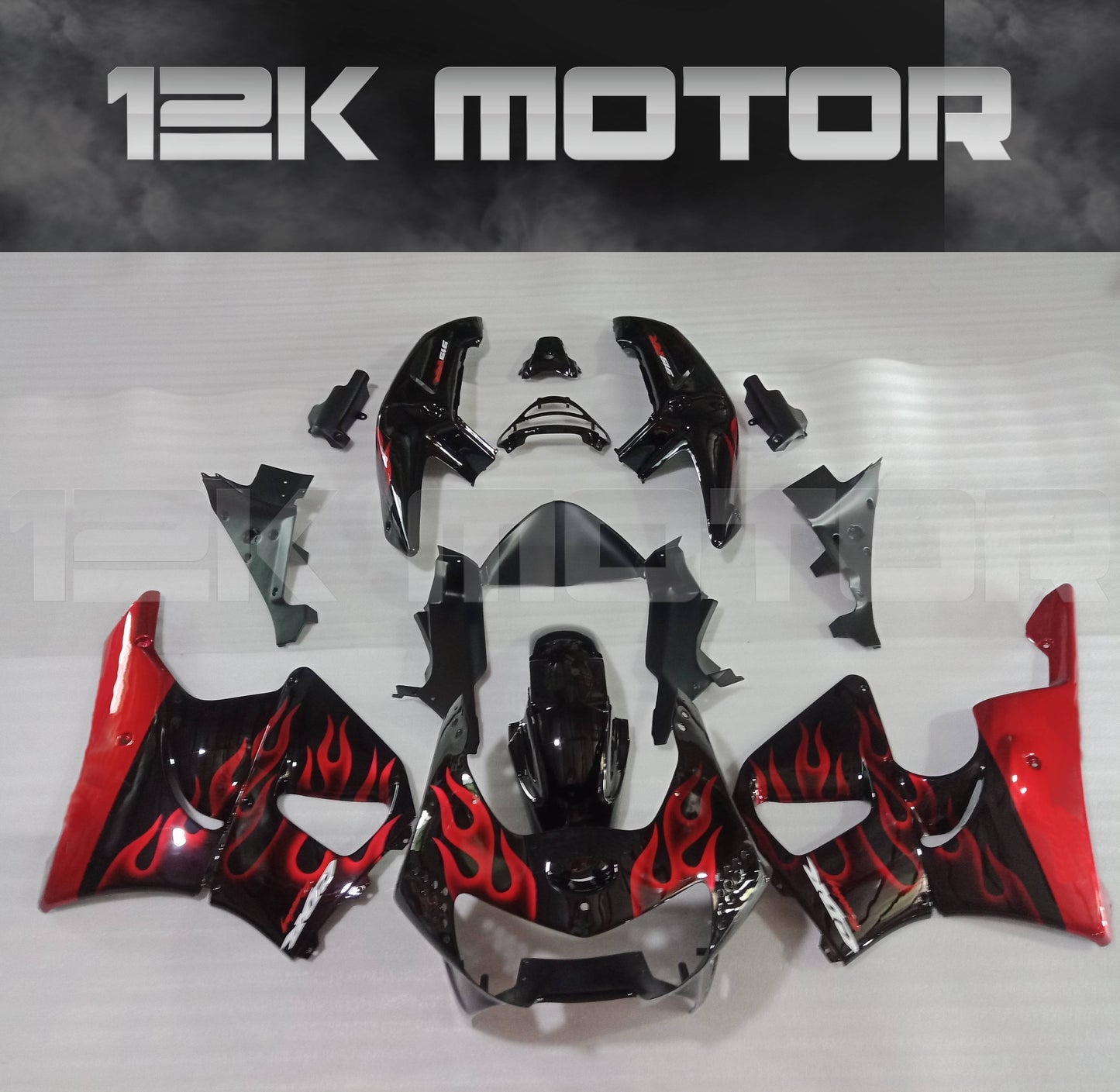 Aftermarket fairing kit for HONDA CBR900RR featuring a red and black flame design on a set of motorcycle fairing parts laid out on a table.