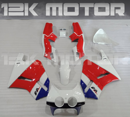 A set of red and white motorcycle fairings laid out on a table, including various panels and parts typically found on a Honda VFR400 NC30.