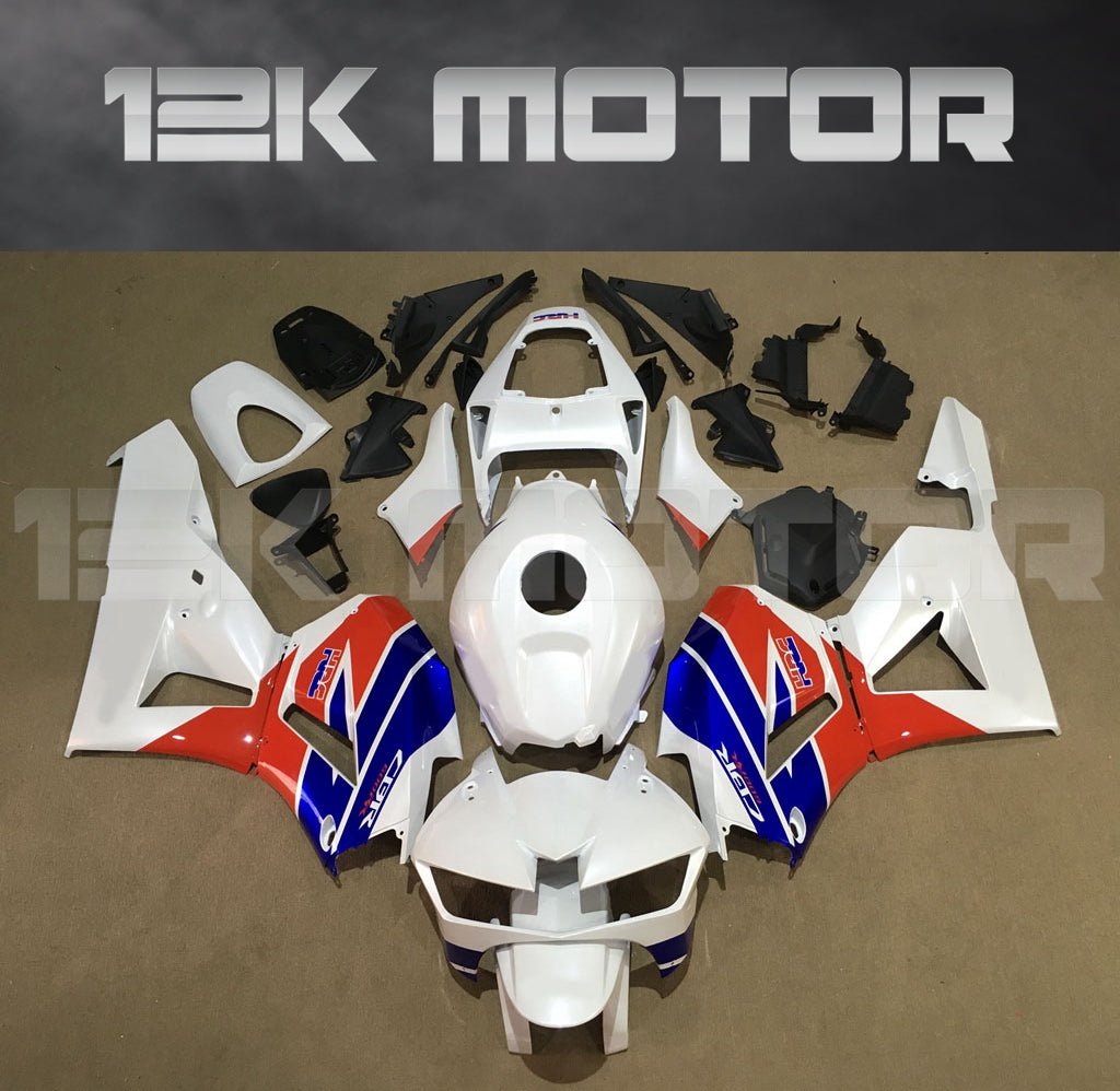Aftermarket fairing kits for HONDA CBR600RR displayed on a table, featuring a combination of white, red, and blue panels.